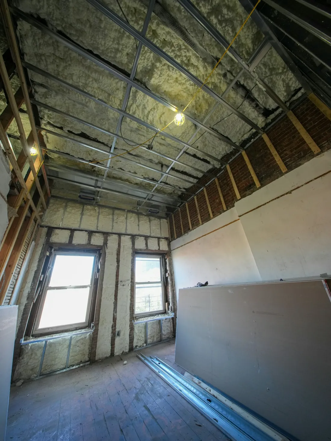 Spray foam insulation visible between exposed framing during a home renovation